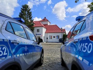 Na zdjęciu widoczne są dwa policyjne radiowozy. W tle budynek Posterunku Policji w Tykocinie.