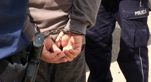 policjant z zatrzymanym mężczyzna w kajdankach
