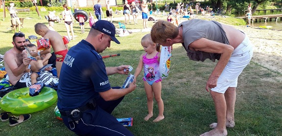 policjant wręcza materiały profilaktyczne