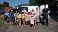 policjanci z dziećmi przy radiowozie