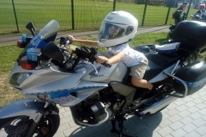 Dziecko w kasku na policyjnym motocyklu
