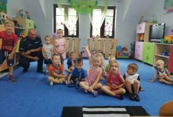 Na zdjęciu widoczna jest grupa przedszkolaków w towarzystwie policjanta.