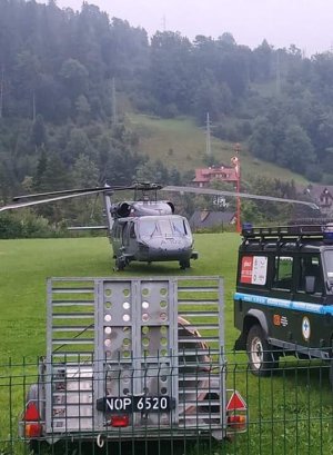 śmigłowiec stojący na trawie oraz pojazd gopr