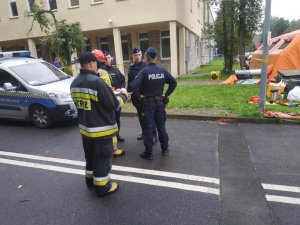 policjanci i strażacy stoją na ulicy