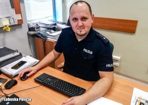 policjant siedzi przy biurku