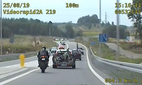 zdjęcie motocyklisty wyprzedzającego samochody