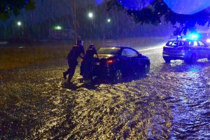 Policjanci pomagający wypchnąć podtopiony pojazd