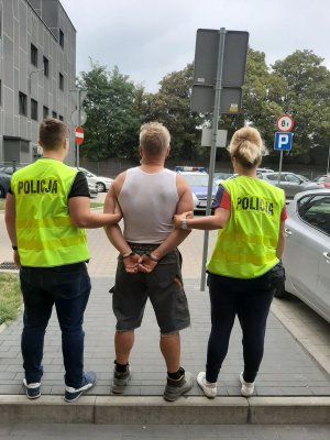 zatrzymany prowadzony przez policjantkę i policjanta