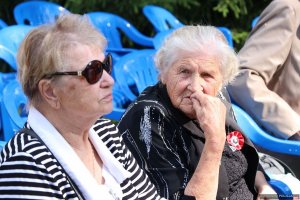 6. Uroczystości na cmentarzu w Miednoje - dwie starsze kobiety siedzą w zamyśleniu