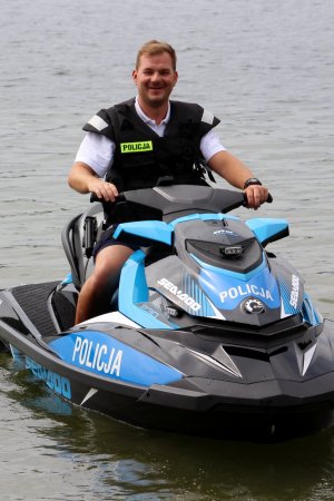 Sierżant sztabowy Patryk Chrastek z Komisariatu Wodnego Policji w Poznaniu siedzi na skuterze wodnym policyjnym