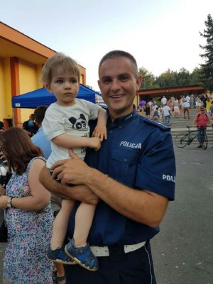 Policjant z dzieckiem na rękach