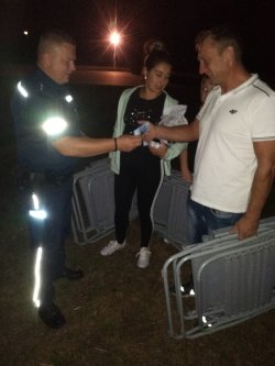 policjant rozdaje ulotki profilaktyczne