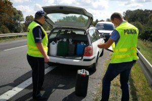 olicjanci przy samochodzie sprawcy wykonują czynności