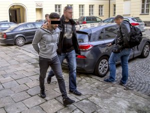 policjant prowadzi zatrzymanego mężczyznę