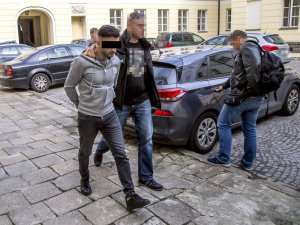 policjant prowadzi zatrzymanego mężczyznę