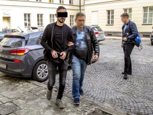 policjant prowadzi zatrzymanego