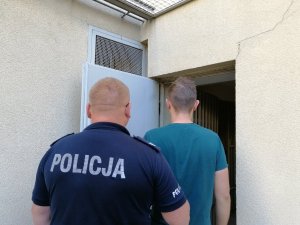 policjant prowadzi zatrzymanego