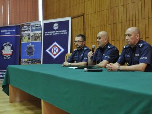 Na zdjęciu widnieją trzej policjanci siedzący przy stole.