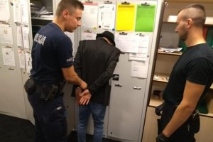 Policjanci z osobą zatrzymaną w Izbie Wytrzeźwień.