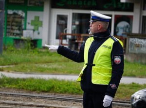policjant z ręką wyciągniętą w bok