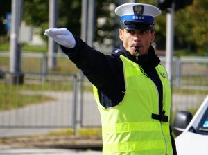 policjant z w żółtej kamizelce kieruje ruchem