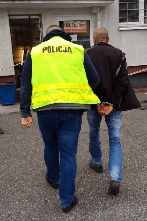 policjant prowadzi zatrzymanego