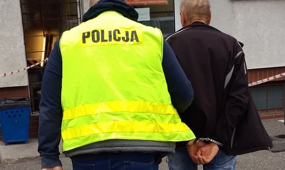 policjant prowadzi zatrzymanego