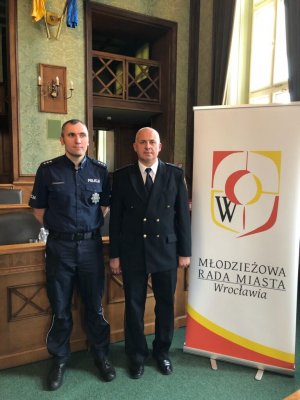 Komisarz Bartłomiej Majchrzak z Zespołu ds. Ochrony Praw Człowieka Komendy Wojewódzkiej Policji we Wrocławiu wraz ze przedstawicielem Straży Miejskiej we Wrocławiu