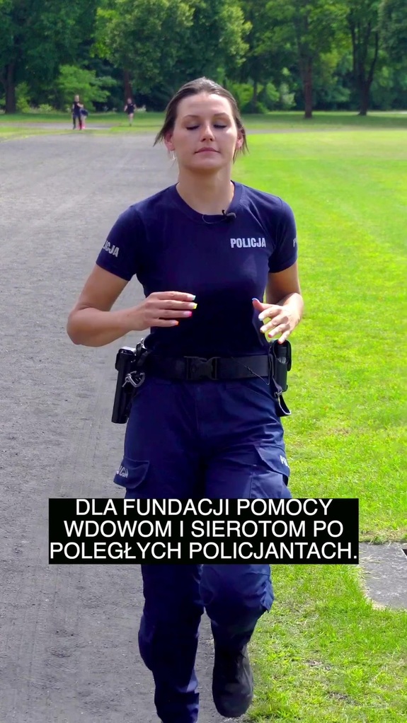 Policjantka biegnie po ścieżce w parku.