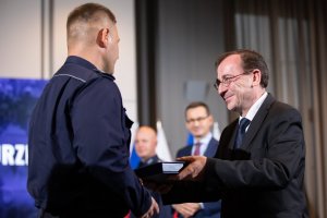 minister Mariusz Kamiński wręcza wyróżnienie policjantowi