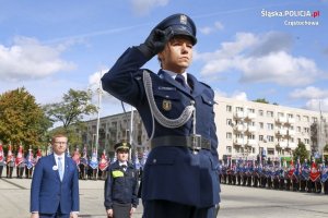 Policjantka oddająca honor za nią Prezydent Miasta Częstochowy obok niego strażniczka miejska, w tle policjanci ze sztandarami