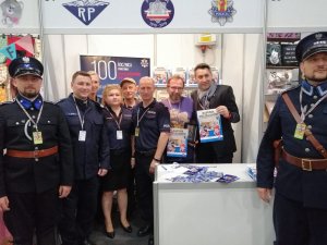 Stoisko promocyjne Policji podczas 30. Międzynarodowego Festiwalu Komiksu i Gier w Łodzi – na zdjęciu m.in.  I Zastępca Komendanta Wojewódzkiego Policji w Łodzi insp. Tomasz Olczyk, Prezes Stowarzyszenia „Rodzina Policyjna 1939 r. w Łodzi” Jarosław Olbrychowski oraz naczelnik Wydziału Promocji Policji Biura Komunikacji Społecznej KGP mł. insp. Monika Florczuk.