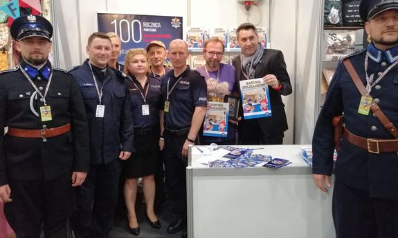 Stoisko promocyjne Policji podczas 30. Międzynarodowego Festiwalu Komiksu i Gier w Łodzi – na zdjęciu m.in.  I Zastępca Komendanta Wojewódzkiego Policji w Łodzi insp. Tomasz Olczyk, Prezes Stowarzyszenia „Rodzina Policyjna 1939 r. w Łodzi” Jarosław Olbrychowski oraz naczelnik Wydziału Promocji Policji Biura Komunikacji Społecznej KGP mł. insp. Monika Florczuk.