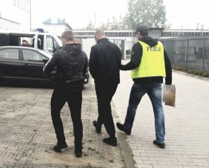 policjanci prowadzą zatrzymanego