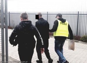 policjanci prowadzą zatrzymanego