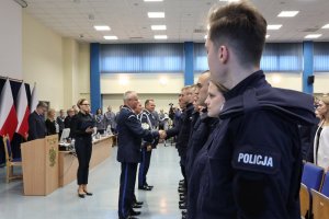 uroczystość w auli - nowo przyjęci policjanci przyjmują gratulacje