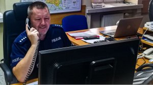 Dyżurny Komendy Policji rozmawia przez telefon na stanowisku kierowania