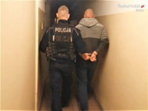 policjant prowadzi zatrzymanego