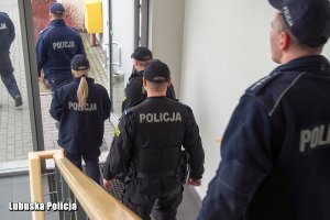 grupa policjantów wychodząca z budynku komendy policji