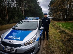 umundurowany policjant ruchu drogowego stojący obok radiowozu