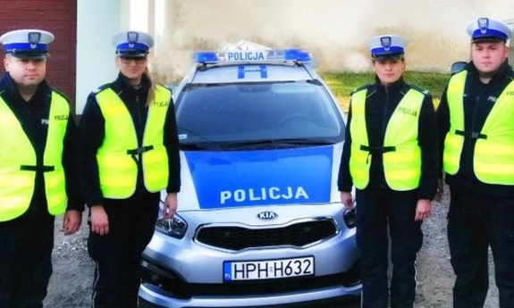 Sierż. szt. Anna Kowalczyk, sierż. szt. Krzysztof Nalewajka, St. sierż. Lena Wiśniewska i sierż. szt. Rafał Chorchos stoją przy radiowozie