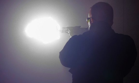 Policjant strzelający z kałsznikowa.