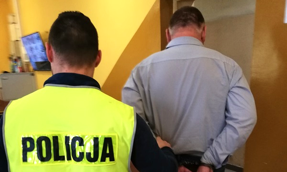 policjant prowadzi zatrzymanego