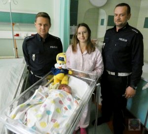 dwaj policjanci oraz kobieta z nowo narodzonym dzieckiem
