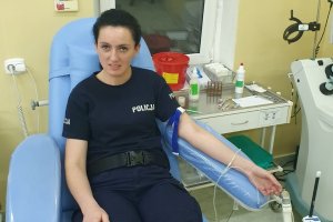 Policjantka tuż przed wbiciem igły do oddawania krwi.