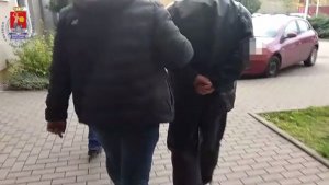 policjant prowadzi zatrzymanego mężczyznę