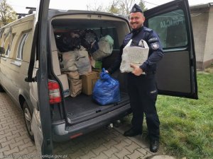policjant wyjmuje z samochodu zebrane rzeczy
