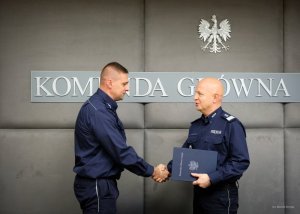 komendant główny policji wręcza policjantowi podziękowanie