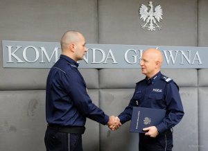 komendant główny policji wręcza policjantowi podziękowanie