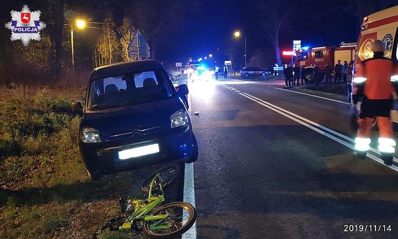 samochód stojący na poboczu i leżący przed nim dziecięcy rowerek